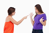 Teenage girl accusing her friend while pointing finger at her