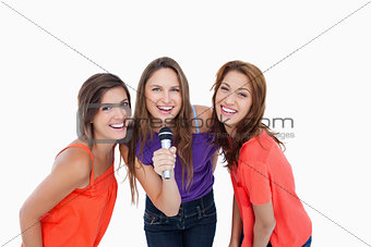 Teenagers smiling while singing a karaoke