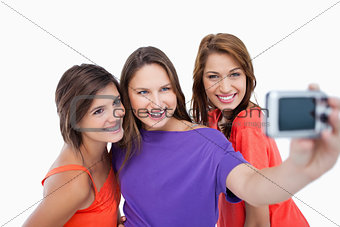 Three beautiful teenagers showing beaming smile in front of the 