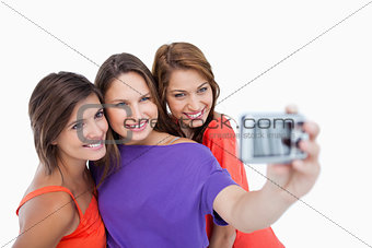 Three beautiful teenage girls standing side by side while being 