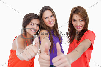 Happy teenagers standing side by side with their thumbs up