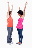 Two dynamic teenagers raising their arms in satisfaction