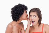 Teenage girl telling a surprising secret to a friend