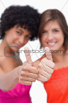 Thumbs up showed by two happy teenage girls