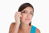 Teenager applying eyeshadow in a concentrated way