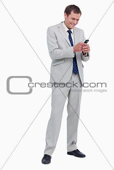 Smiling businessman reading text message