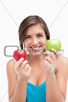 Smiling young woman holding two apples