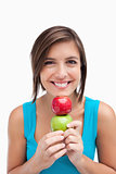 Teenager smiling and holding two apples between her hands and he