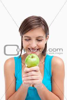 Smiling teenager looking at a green apple placed on her hands cr