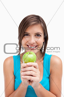 Smiling teenager crossing her hands which are holding a green ap