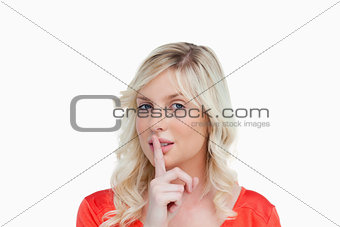 Young attractive woman telling to be quiet through a hand sign