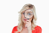 Fair-haired woman looking through a magnifying glass