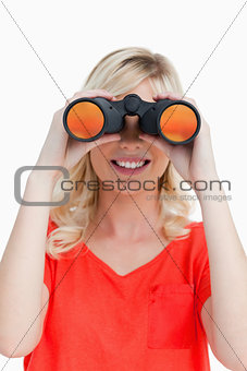 Smiling woman looking through binoculars