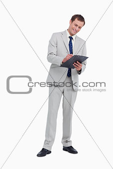 Smiling businessman taking notes