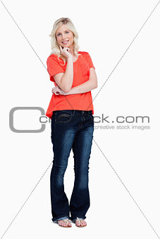 Smiling teenager standing with her finger on her cheek 