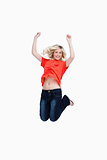 Dynamic teenager energetically jumping while raising her arms ab