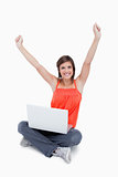 Attractive young woman sitting cross-legged and raised arms