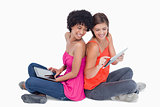 Smiling teenage proudly showing her tablet PC to her friend