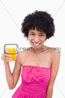 Young smiling woman holding a glass of orange juice