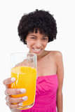 Glass of orange juice held forward by an attractive teenage