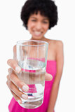 Glass of pure water held by an attractive teenage girl
