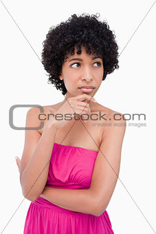 Thoughtful teenage girl putting her hand on her chin while looki