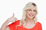 Smiling young blonde woman putting her thumbs up in agreement