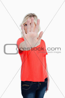 Young blonde woman making the stop sign with her hand