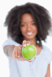 Green apple held by a young woman with curly hair