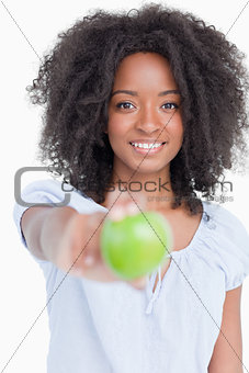 Smiling young woman holding a delicious green apple