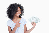 Young woman closing her eyes while pointing her finger on dollar