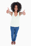 Young relaxed woman standing upright with her thumbs up