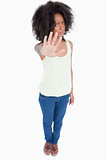 Young woman standing upright while making the hand stop sign