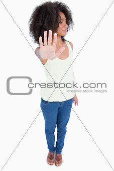 Young woman looking on the side while making the hand stop sign
