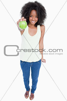 Relaxed young woman holding a green apple in front of her