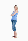 Relaxed young woman standing upright with arms crossed