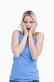 Surprised blonde woman placing her hands on her cheeks