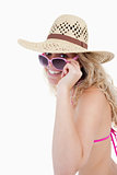 Smiling teenager in a swimsuit looking over her sunglasses