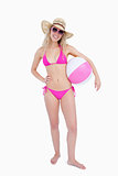 Smiling teenager in beachwear holding a beach ball