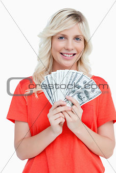 Young attractive woman holding dollar notes in a fan shape