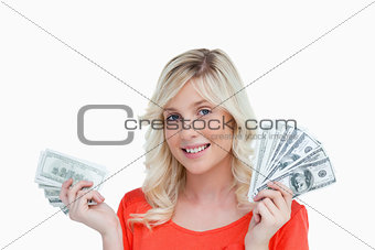 Woman showing a great smile while holding two fans of dollar not