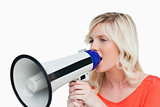Young woman looking on the side while speaking into a megaphone