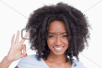 Young woman making the OK sign while smiling