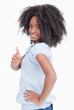 Side view of a smiling woman showing her thumbs up with a hand o