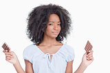 Young woman holding two pieces of chocolate