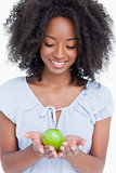 Young woman looking at the green apple held by her