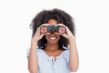 Young woman with curly hair looking through binoculars