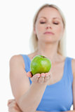 Beautiful green apple held by a blonde woman