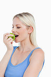 Beautiful blonde woman eating a delicious green apple