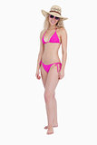 Attractive woman standing upright wearing pink swimsuit with a h